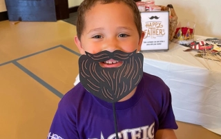 Boy Posing with Fake Mustache and Beard Prop